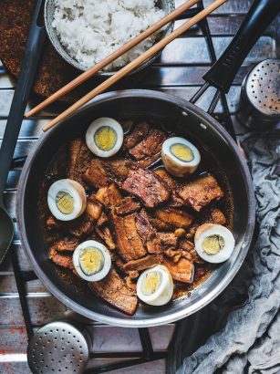 mouthwatering pork adobo with eggs beside the bowl of rice